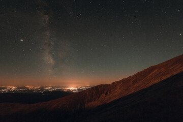 Milky way galaxy and the city from the mountain
