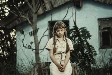 Obraz na płótnie Canvas sad teenage girl sitting by an abandoned building