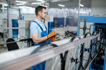 Worker at the machine tool makes bicycle rim