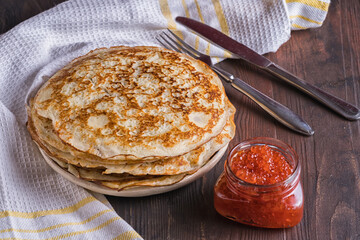 Pancakes on a plate and red caviar. Pancake day. Russian tradition in the last week before Easter, there are pancakes with different fillings.
