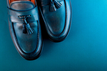 Blue loafer shoes on blue background. One pair. Top view.