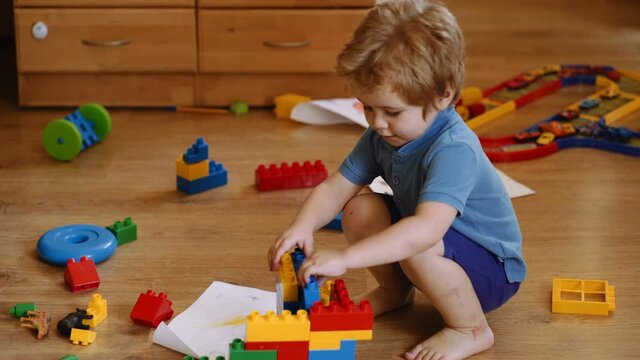 Kid playing in kindergarten room. Kids playing. Children at day care. Child and toys. Cute funny preschooler playing with construction toy blocks