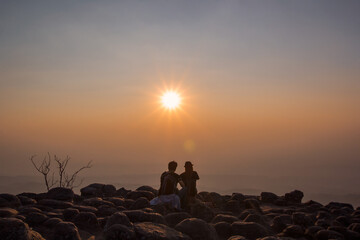 landscape sunset Young people sit and watch the sunset along the cliff.