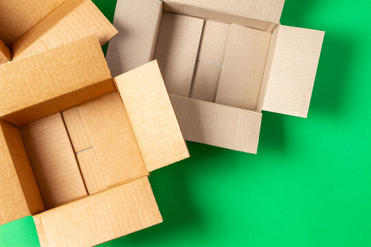Empty open cardboard boxes on light green background. Top view
