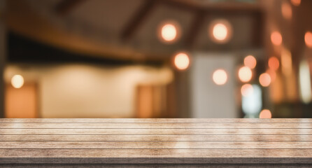 Empty wooden table top with lights bokeh on blur restaurant background	
