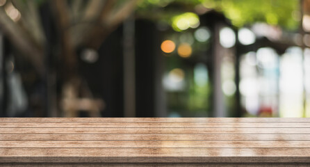 Empty wooden table top with lights bokeh on blur restaurant background	
