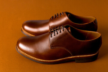 Brown oxford shoes on paper background.