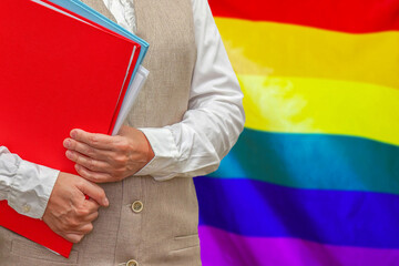 Woman holding red folder on LGBT flag background. Education and jurisprudence concept for LGBT