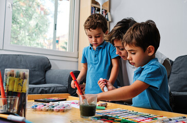 a mother helps her sons to draw and paint