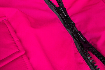 Fragment of red jacket with black zipper. ziplock background.