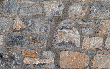 grey and brown stone wall closeup, rough pattern background