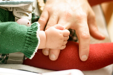 Primer plano de la mano de un bebé sujetando la mano de su papá