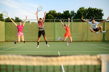 Mixed doubles tennis, players jump near the net