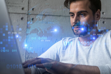 A serious caucasian manager in casual wears, using laptop to develop a new worldwide supply chain. Double exposure. globe and map hologram.