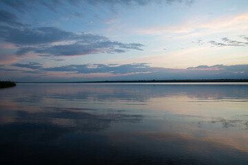 Fototapeta premium colored sunset over the river, with sky reflection