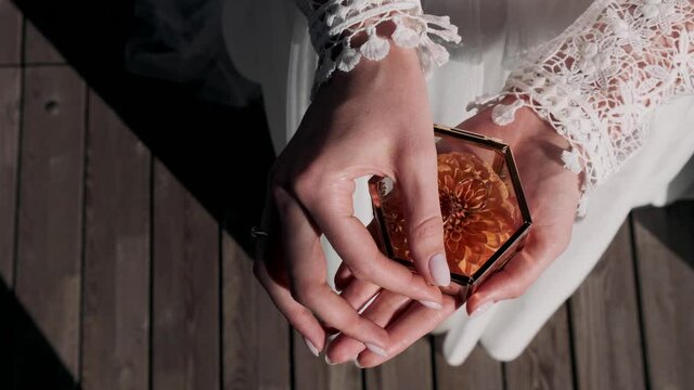 female hands holding a box with rings