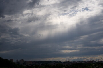 sky with breaking sun rays over the city
