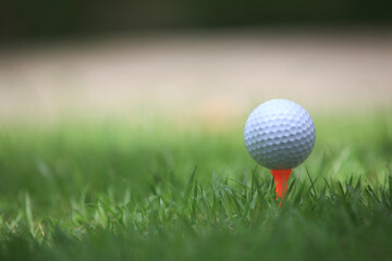 Golf ball on tee ready to be shot , for holiday season concept of golf course background