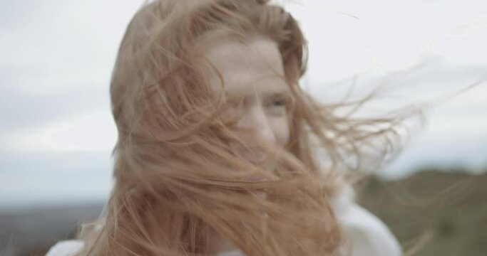 Close up of caucasian redhead woman hair blowing in face outdoors in nature