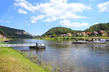 The ferry boat of the town Wehlen on Elbe river with the "Bastei" in the background, Saxon Switzerland - Germany