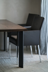 Naklejka na ściany i meble Minimalist kitchen interior with walnut dining table and leather arm chairs