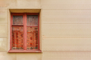 window in the wall of an old house, with a bricked-in opening and a place for text