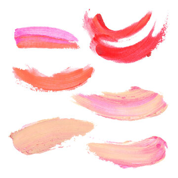 Set of smeared on the surface of red, pink, beige lipstick, foundation, concealer of various shapes. Background from cosmetics. Dirty spots.