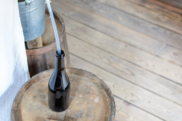 Glass bottle with tube for filling beer from barrel.