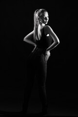 Girl on a black background in fashionable clothes