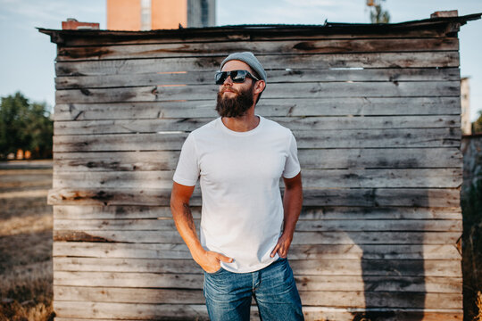 Young bearded hipster guy wearing white blank t-shirt. Mock-up for print. T-shirt template.