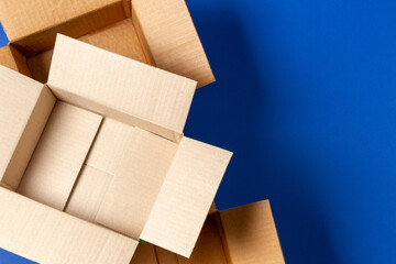 Empty open cardboard boxes on blue background. Top view
