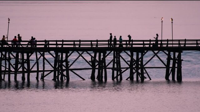 The Mon Bridge is an old wooden bridge located in Sangkla, Thailand. Monks and people cross before sunrise to earn merits and take blessings; in the afternoon, a leisure place to meet friends.