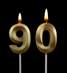 Burning golden birthday candles isolated on black background, number 90	