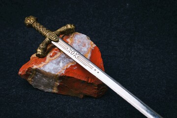 Background with a knight's sword on a red stone with a white stripe