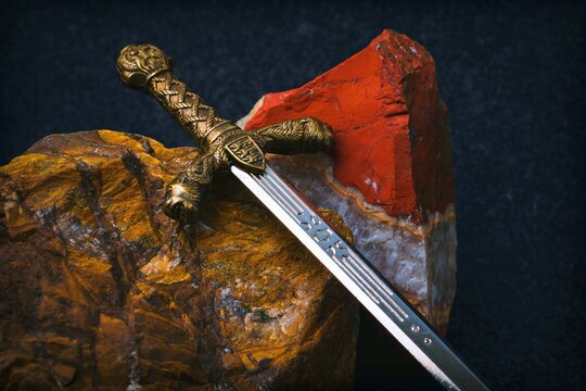 Knight's sword against a background of red and brown stones