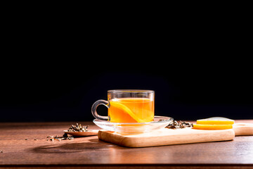 Glass cup of freshly tea with yellow lemon on wood table