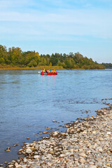 A group of tourists in a rubber boat travel down the Irkut river on a sunny autumn day. Travel and...