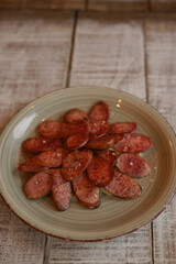 Plate with grilled chorizo in cider slices; typical spanish tapa; in a restaurant