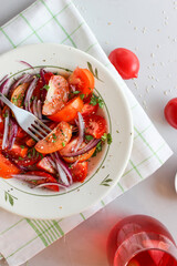 Sliced tomatoes with red onion, spices in oil