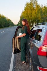 female model plus size in a dark green suit traveling by car