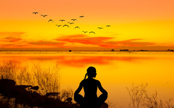 Silueta De Una Mujer Haciendo Yoga Frente Al Lago