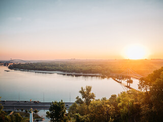 Aerial view of pedestrian Park bridge over the Dnipro river in Kyiv city on summer morning. Urban cityscape background at sunrise. Kiev, Ukraine
