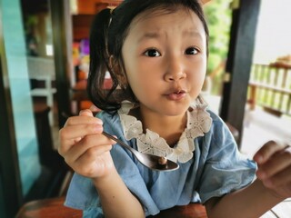 Little girl Happy eating cream cake