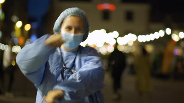 Close view of happy doctor or nurse dancing in city centre to celebrate end of pandemic