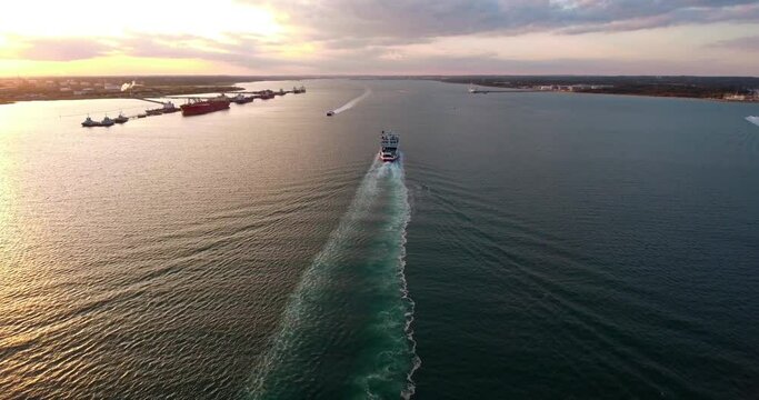 4K Aerial over the Solent Following an​ Isle of Wight ferry going up Southampton water during early evening sunset with small boats passing by.