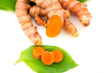 raw organic  turmeric roots with green leaves