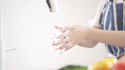キッチンで手を洗う若い女性	