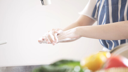 キッチンで手を洗う若い女性	