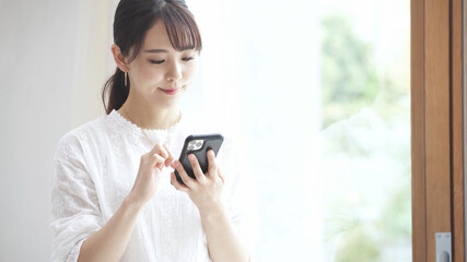 スマートフォンを操作している若い女性
