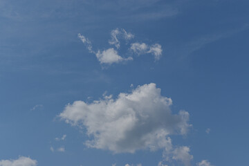 Single white cloud on blue sky background.